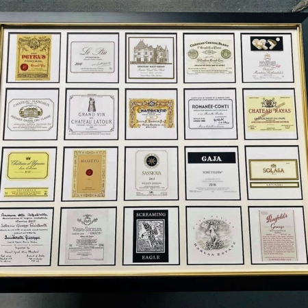Encadrement décoratif composé de plusieurs étiquettes de grands vins et crus prestigieux, idéal pour décoration murale autour du vin