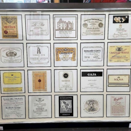 Encadrement décoratif composé de plusieurs étiquettes de grands vins et crus prestigieux, idéal pour décoration murale autour du vin